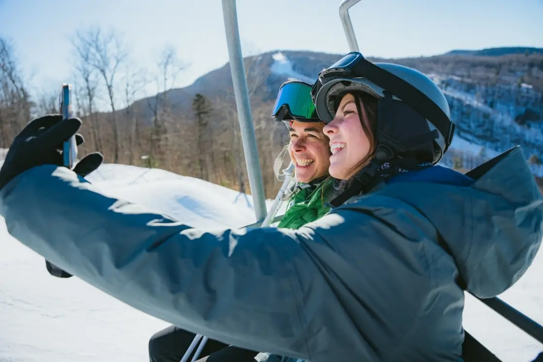 Claire McDonald ’27 takes a selfie with President Sian Leah Beilock on a Dartmouth Skiway chairlift before a run.