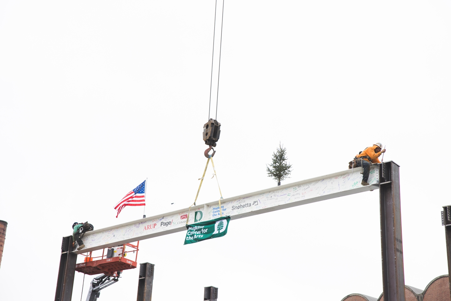Construction workers secure the steel beam over a new recital hall at the Hopkins Center